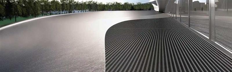 Wide view of a busy industrial workspace with heavy-duty floor mats under machinery and staff, highlighting durability and safety in extreme environments