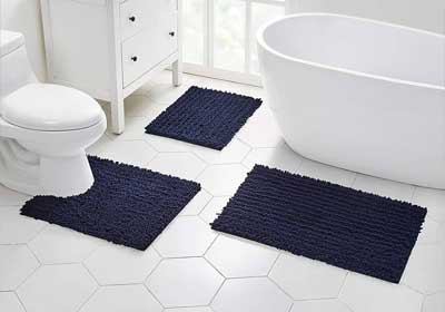 Close-up of plush bath mat texture with non-slip backing on tiled bathroom floor